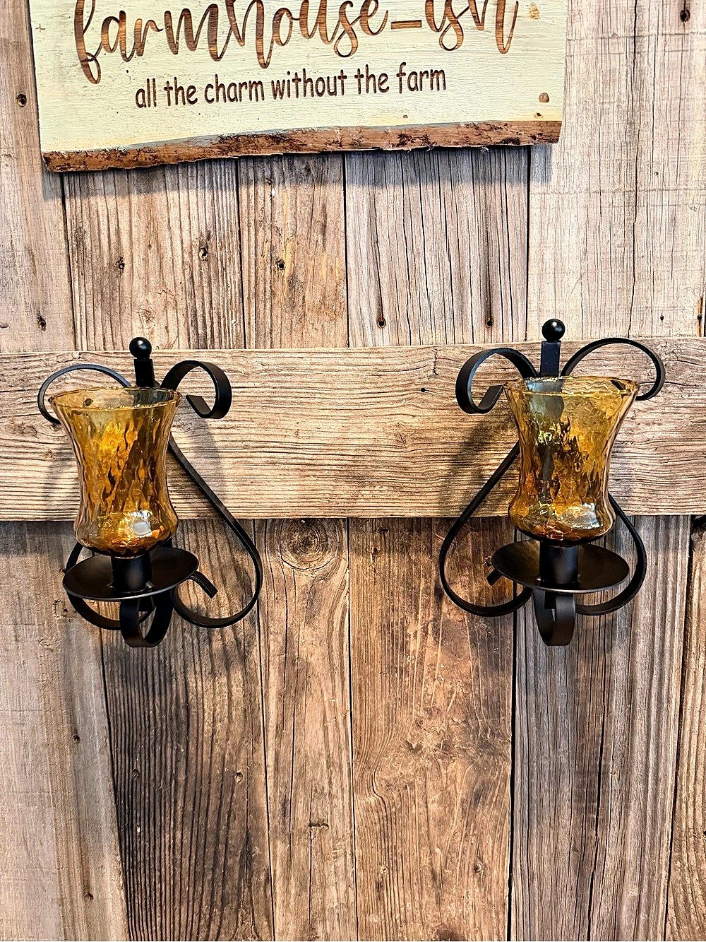 Pair of vintage black gothic wrought iron wall sconces paired with amber glass
